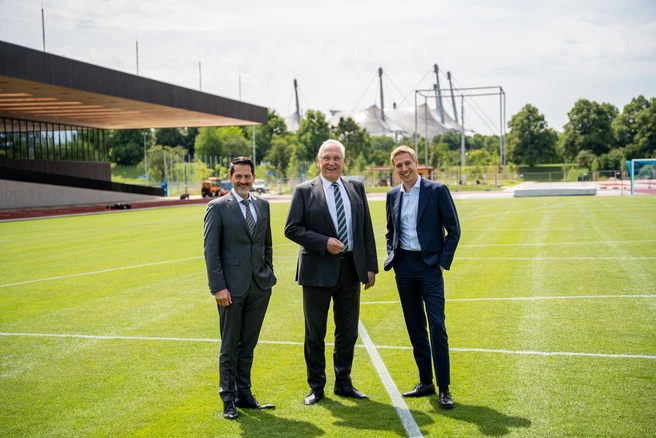 Drei Männer stehen zusammen auf dem TUM Campus im Olympiapark und sprechen freundlich miteinander. TUm Präsident Thomas F. Hofmann, Bayerns Innen- und Sportminister Joachim Herrmann und Münchens Oberbürgermeister Dominik Krause.